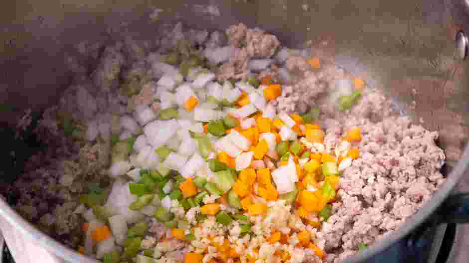 Turkey Bolognese Recipe: When turkey is mostly cooked, drain some of the grease from the pan and clear a space in the center of the pan.