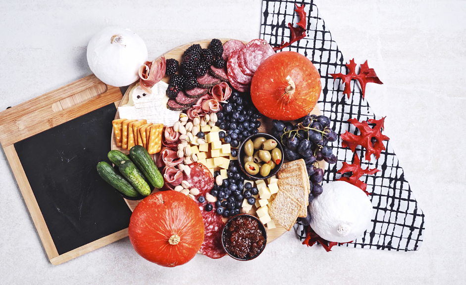 Halloween Charcuterie Board Recipe: Fill the remaining spaces of the board with the butter crackers, water crackers and pistachios.