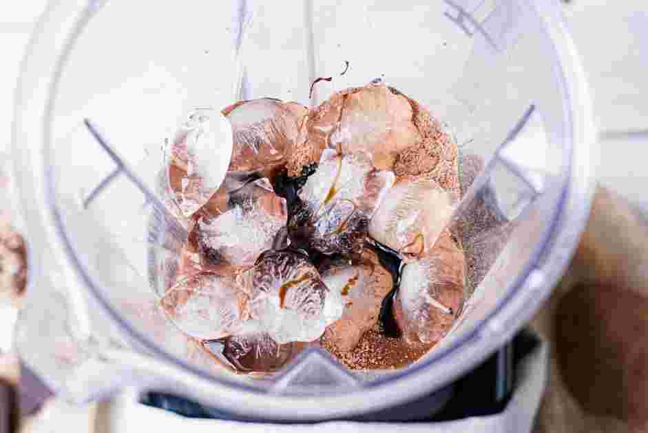 Frozen Hot Chocolate Recipe: In the jar of a blender, add the cold chocolate milk, hot chocolate mix, ice and chocolate syrup.