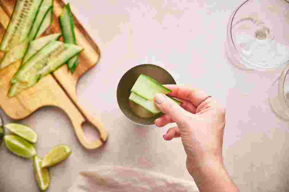 Cucumber Martini Recipe: Place two cucumber slices in a cocktail shaker and use a muddler to mash the cucumber.