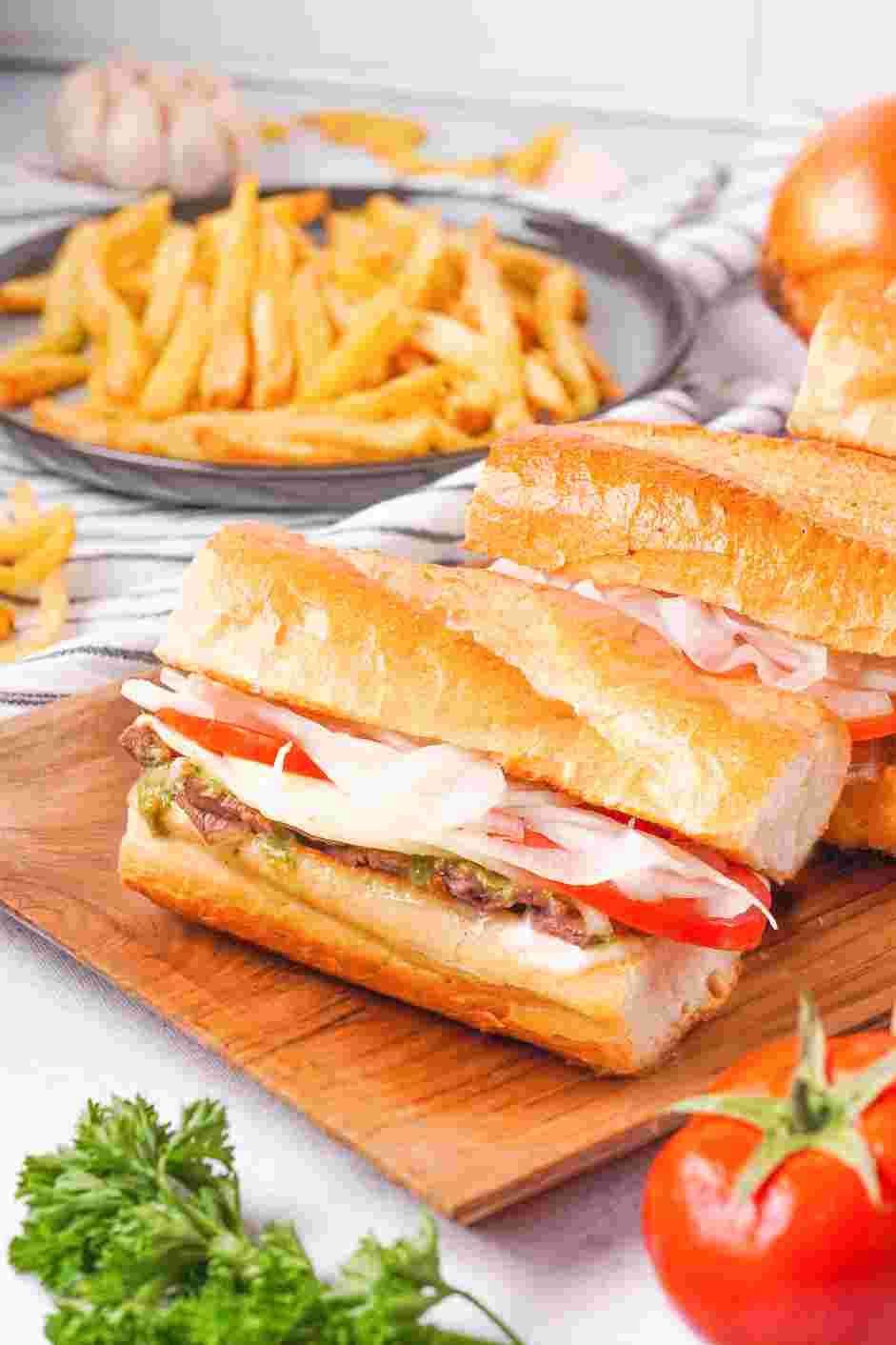 Ribeye Steak Sandwich Recipe: Place thin slices of steak on the bottom and drizzle chimichurri over the steak.