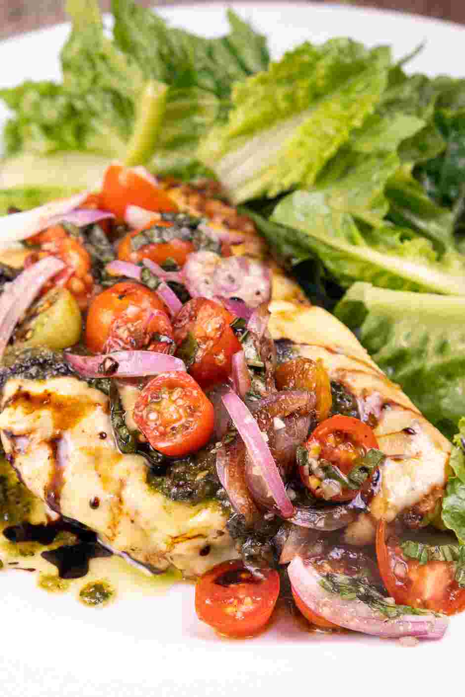 Grilled Chicken Margherita Recipe: Remove the chicken from the grill and top with the pesto and the reserved tomato topping.