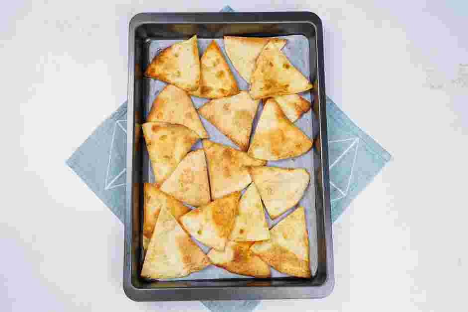 Smores Dip Recipe: On a sheet pan lined with parchment paper, spread the triangular tortillas in an even layer.