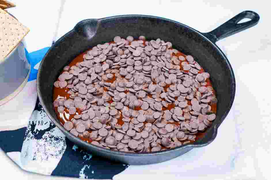 Smores Dip Recipe: Pour the chocolate ganache into the bottom of a 10 or 12 inch cast iron pan and top with the remaining 150 grams of the chocolate chips.