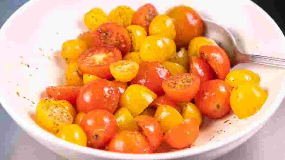 Focaccia Recipe: While the dough is resting, prepare the tomatoes by slicing them in half and seasoning it with salt, olive oil and dried oregano.