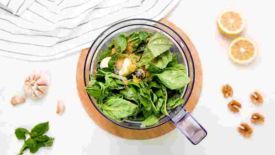 Vegan Pesto Recipe: In the bowl of a food processor, place the toasted walnuts (or pine nuts), basil leaves, garlic cloves, nutritional yeast, lemon juice, salt and pepper.