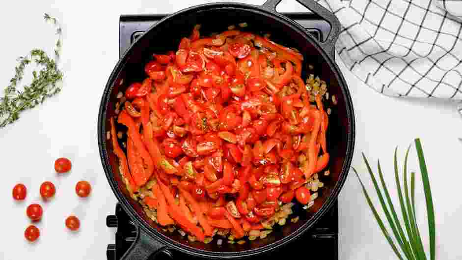 Shakshouka Recipe: Remove the lid, add the quartered cherry tomatoes and stir.