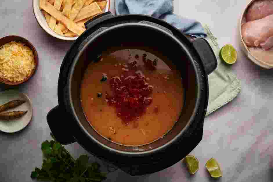 Instant Pot Chicken Tortilla Soup Recipe: Add the chicken stock, drained black beans, fire roasted diced tomatoes and mild green chiles.