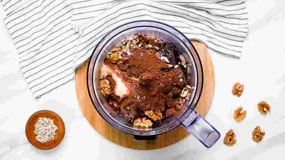 Date Bars Recipe: In the bowl of a food processor, add the pitted Medjool dates, walnuts, sunflower seeds, cocoa powder, almond butter and salt.