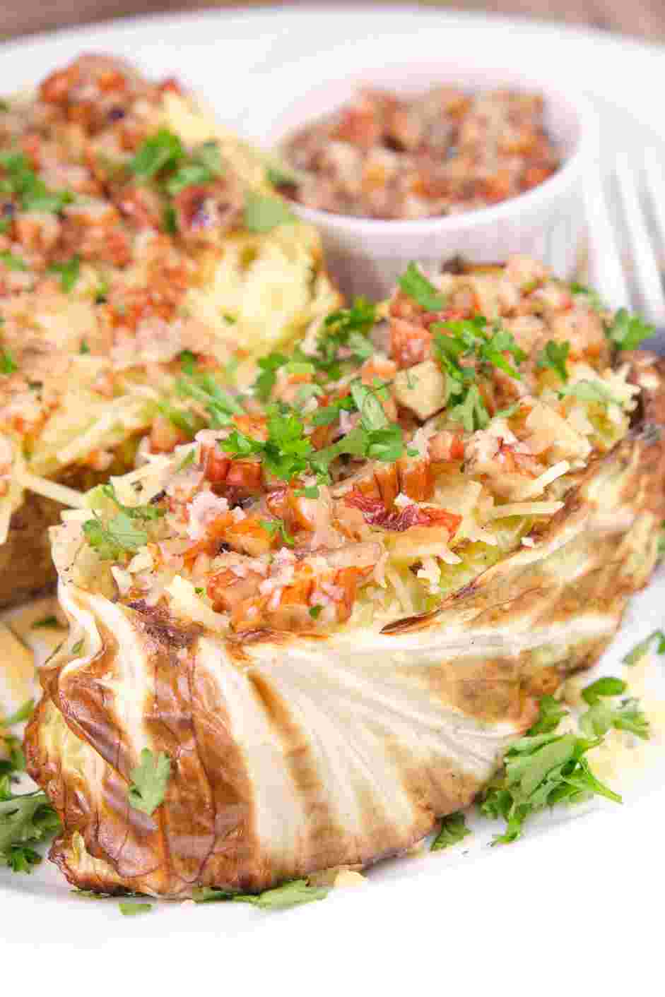 Cabbage Steaks Recipe: Spoon the topping over the cabbage steaks and garnish with chopped parsley.