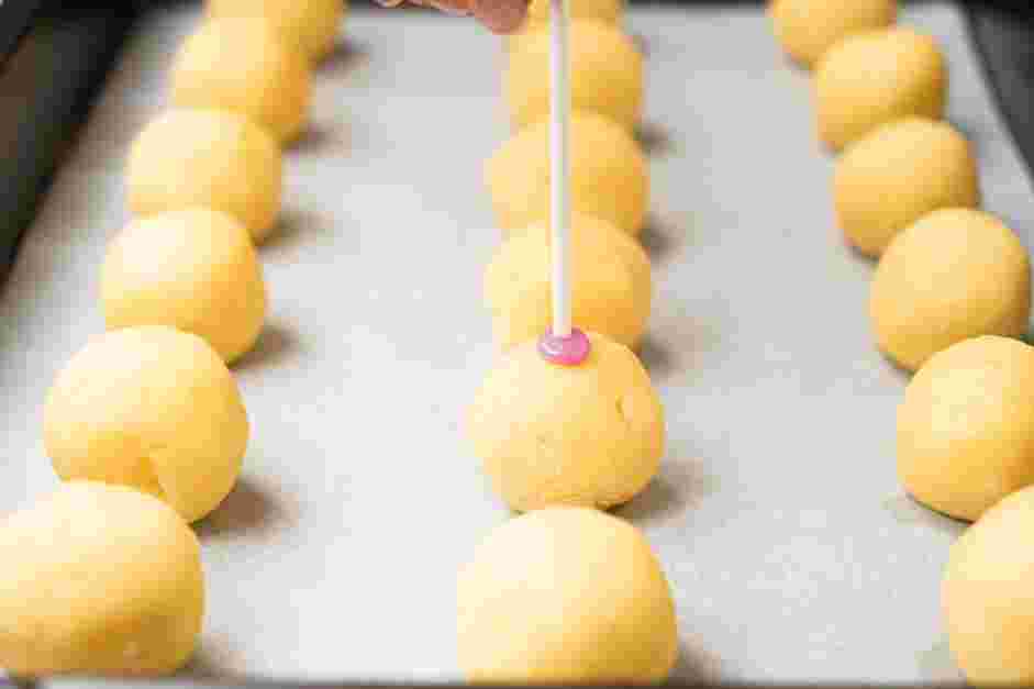 How to Make Cake Pops Step 7: Insert the dipped end about halfway into a cake ball.