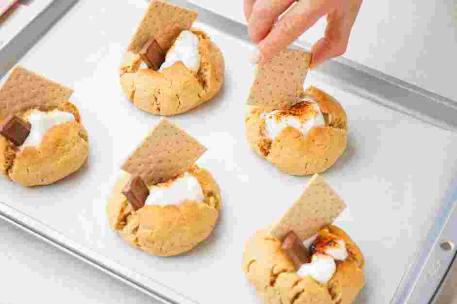 S’mores Cookies Recipe: Stick a graham cracker square and a chocolate rectangle into the toasted marshmallow top.