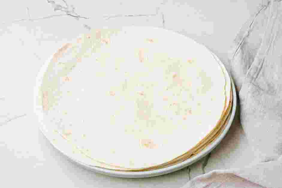 Black Bean Crunchwrap Supreme Recipe: Warm the flour tortillas by placing them on a microwave-safe plate topped with a few drops of water.