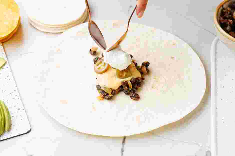 Black Bean Crunchwrap Supreme Recipe: Top with pickled jalapeños and a dollop of sour cream.