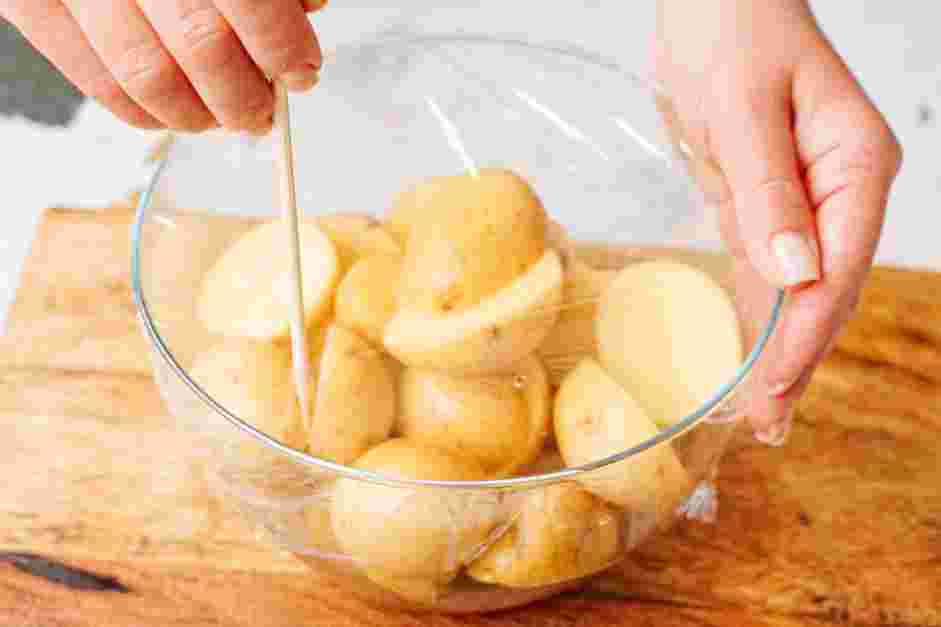 Parmesan Crusted Potatoes Recipe: Add the water to the bowl and cover it with plastic wrap.