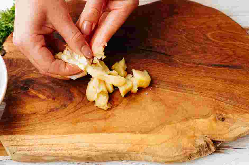 Garlic Parmesan Wings Recipe: On a cutting board, squeeze the garlic cloves out of the roasted garlic head.
