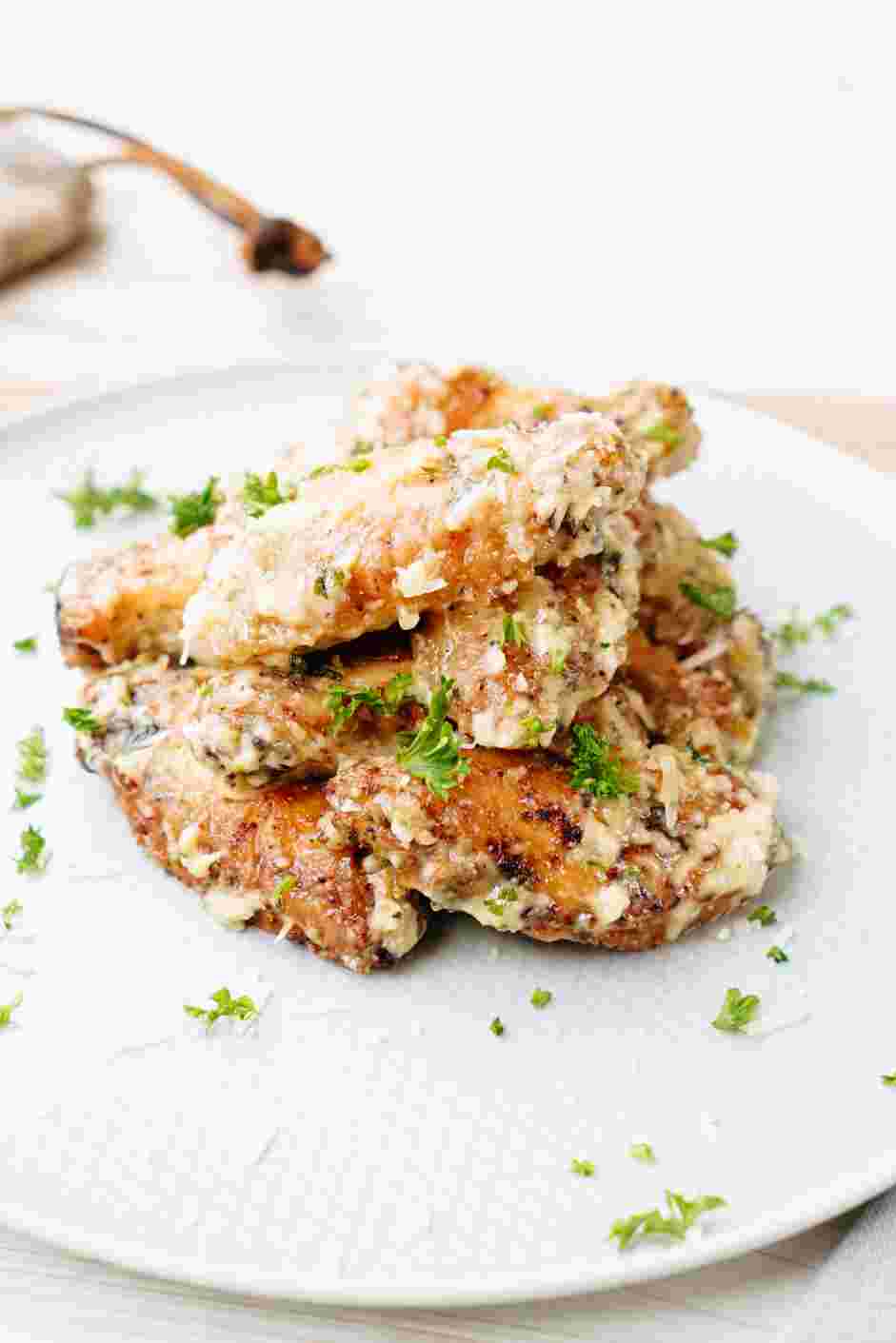 Garlic Parmesan Wings Recipe: Transfer the chicken wings to a plate and garnish with extra Parmesan and parsley.