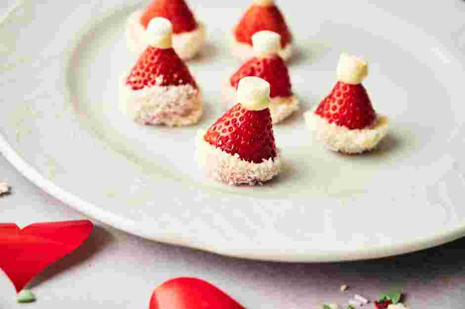 Grinch Punch Recipe: Dip the halved mini marshmallow in the white chocolate and place it on top of the strawberry.