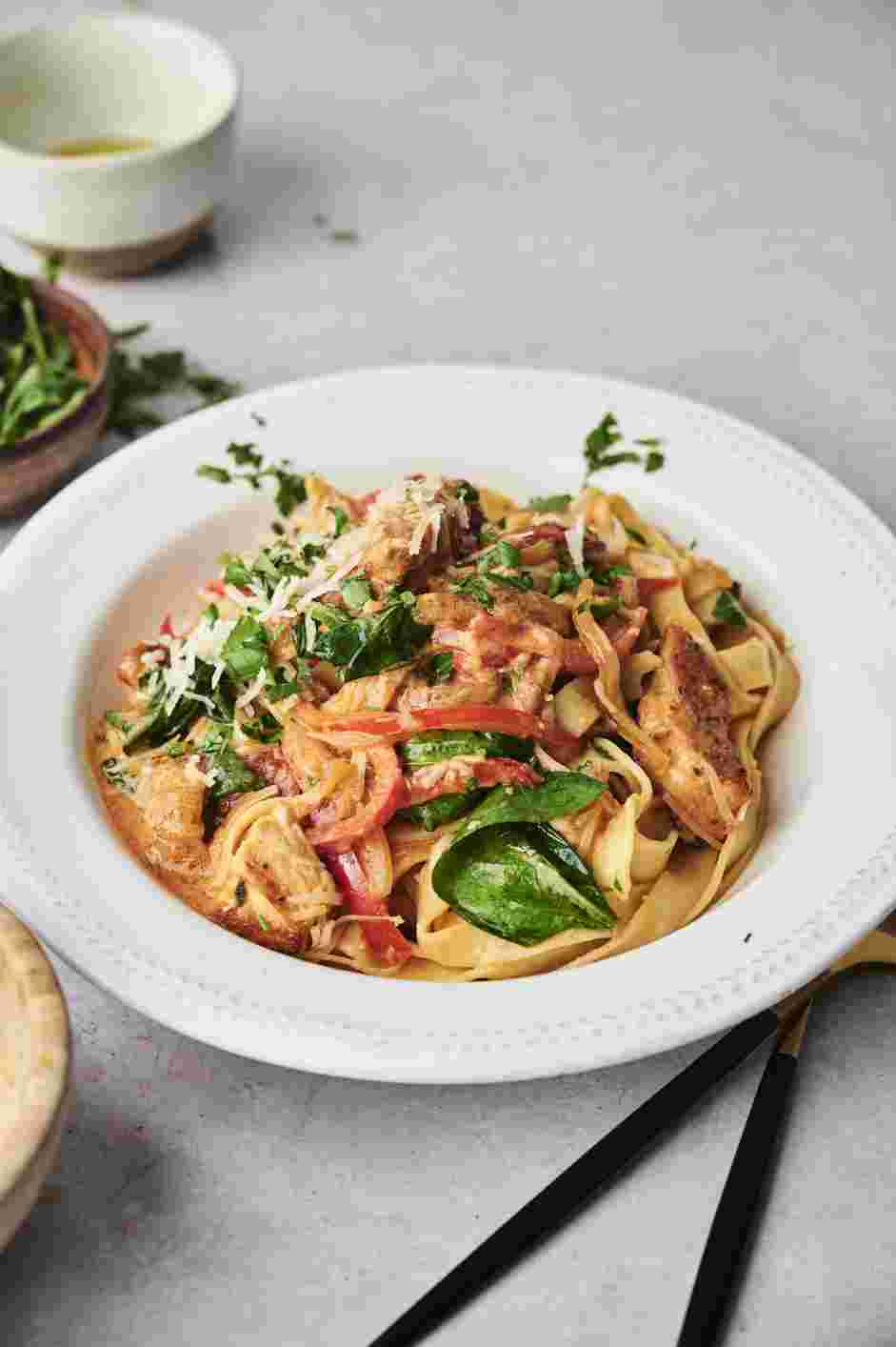 Tuscan Chicken Pasta Recipe: Garnish with extra Parmesan cheese and finely chopped parsley.