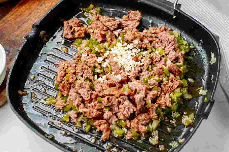 Chopped Cheese Sandwich Recipe: Mix the green bell pepper and onion with the beef and cook until the beef is no longer pink.