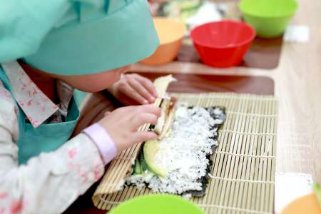 a kid making homemade sushi