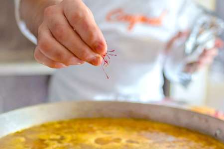 chef adding saffron to paella