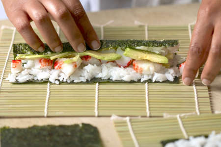 chef rolling california roll sushi