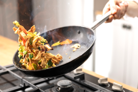 chef stir frying meat and vegetables