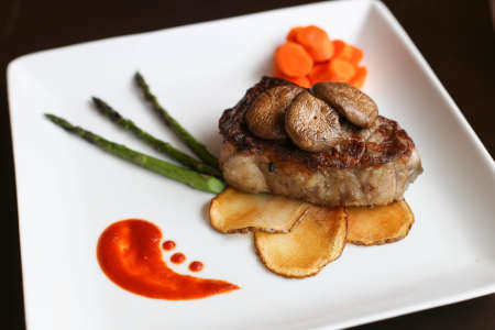 Sirloin steak, potato slices, carrots, mushrooms and asparagus