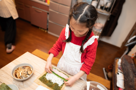 kid making sushi rolls