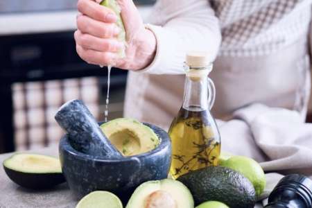 person adding fresh lime to guacamole