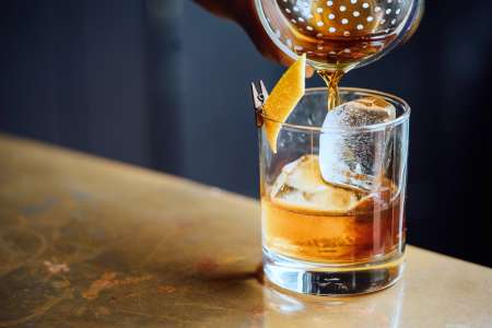 pouring an old fashioned cocktail