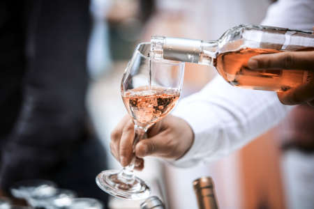 sommelier pouring a glass of rose wine