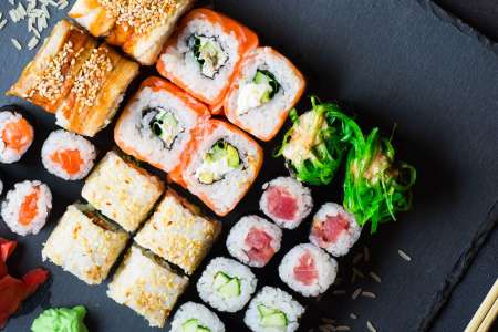 sushi rolls and nigiri on a black slate tray
