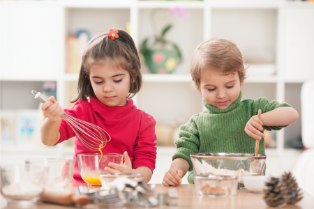 two kids mixing ingredients in separate bowls