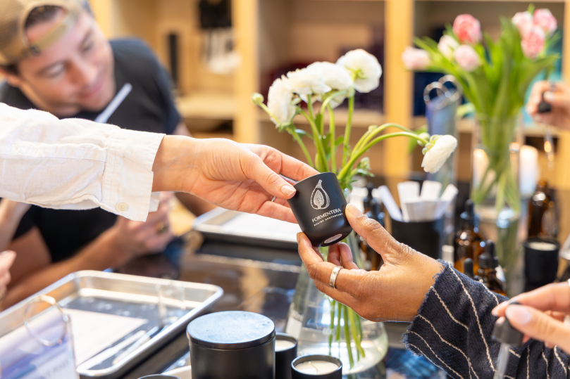 Dallas - Instructor handing a custom candle container to a student during a workshop Shot