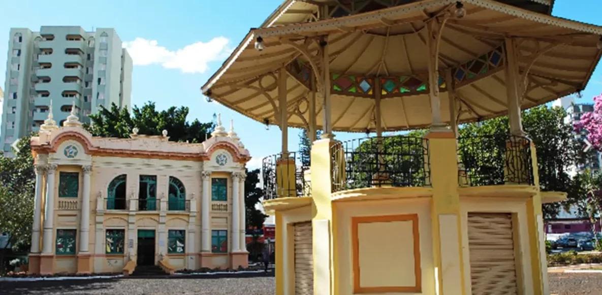 Imagem de uma praça e um prédio histórico em tons de laranja ilustrando hotel perto da rodoviária de Uberlândia.