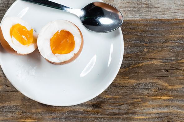 Ein aufgeschlagenes Ei mit Löffel