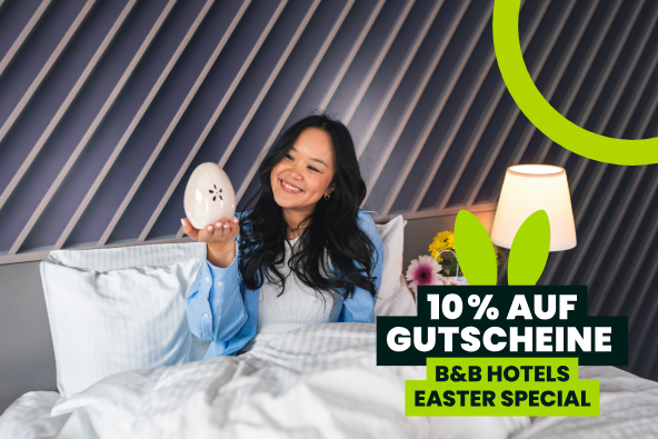 Frau im B&B Hotelzimmer hält Osterei | B&B HOTELS