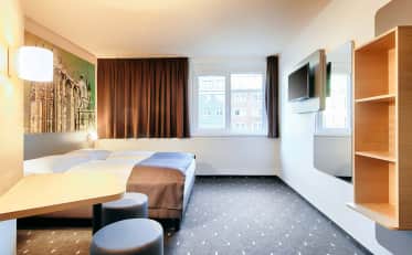 Modern B&B HOTEL room with comfortable double bed and city view