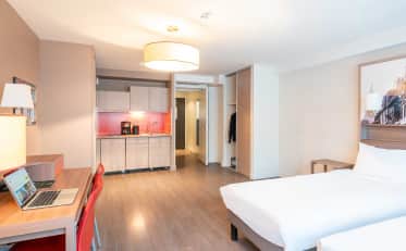Modernes Hotelzimmer im B&B HOME mit Kochnische und komfortablem Arbeitsbereich mit Laptop