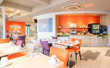Moderner Frühstücksbereich im B&B HOME mit orangefarbenen Wänden und Buffetstation
