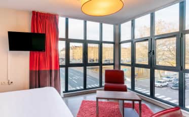 Modern hotel room at B&B HOME with floor to ceiling windows and city river view