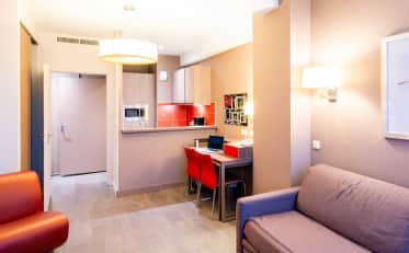 Modernes B&B HOME Studio Apartment mit Küchenzeile und gemütlichem Wohnbereich mit Sofa und Arbeitsplatz