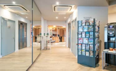 Moderne B&B HOME Hotellobby mit Aufzug und Touristeninformationsstand in der Nähe des Empfangsbereichs