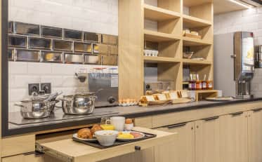 Modern breakfast buffet station at B&B HOME featuring fresh pastries and hot food options