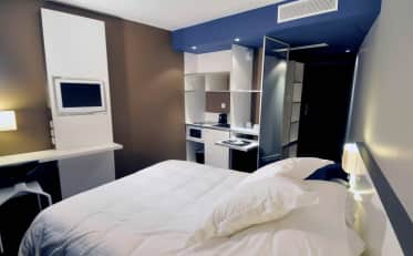Chambre studio moderne à B&B HOME avec lit double confortable et kitchenette équipée d'appareils électroménagers