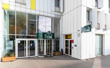 Facciata esterna moderna e ingresso dell'hotel B&B HOME con porte a bussola in vetro e architettura contemporanea