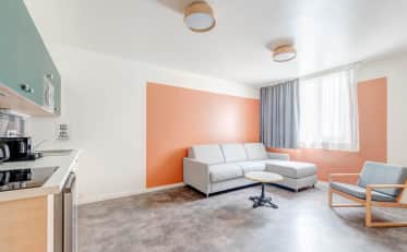 Zona giorno moderna presso B&B HOME con angolo cottura e comodo divano grigio