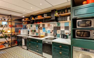 Moderna cucina in comune presso B&B HOME con piastrelle colorate ed elettrodomestici professionali